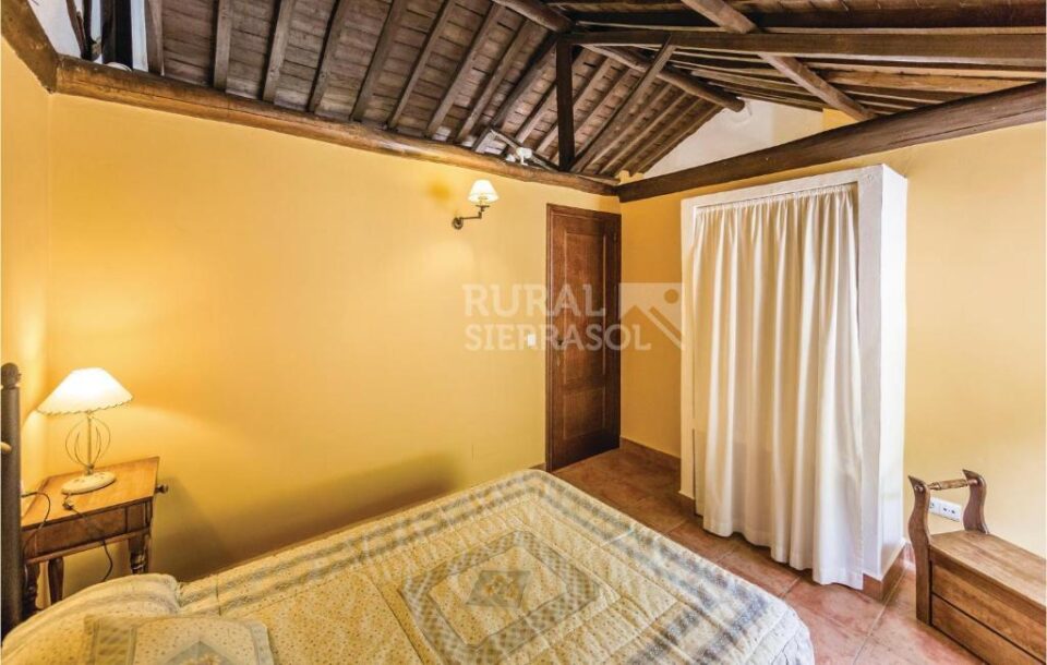 Habitación con cama doble y armario de Casa rural en Cuevas del Becerro (Málaga)-1091
