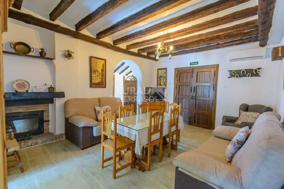 Salón con mesa y sofás de Casa rural en Alcaucín (Málaga)-3698