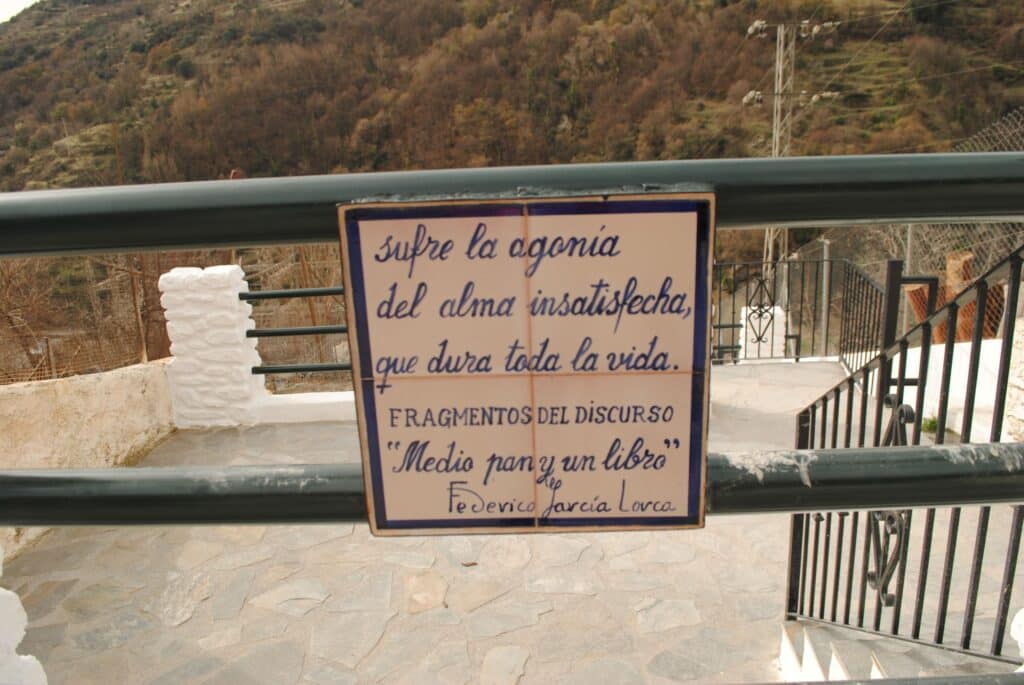 Octavo verso del Paseo Federico García Lorca en Pampaneira que dice: sufre la agonía del alma insatisfecha, que dura toda la vida. Fragmentos del discurso "Medio pan y un libro"