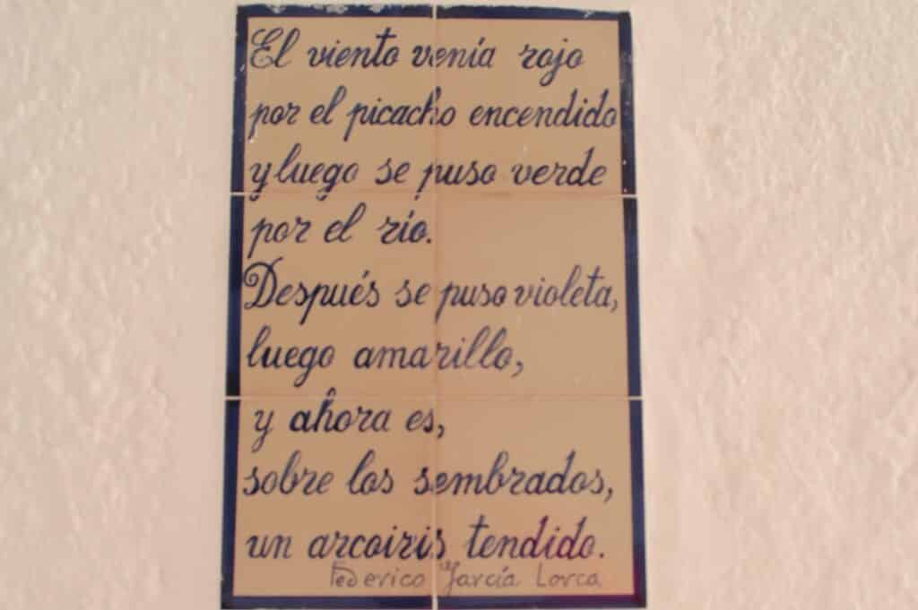 Primer verso del Paseo Federico García Lorca en Pampaneira que dice: El viento venía rojo por el picacho encendido y luego se puso verde por el río. Después se puso violeta, luego amarillo, y ahora es, sobre los sembrados, un arcoíris tendido.