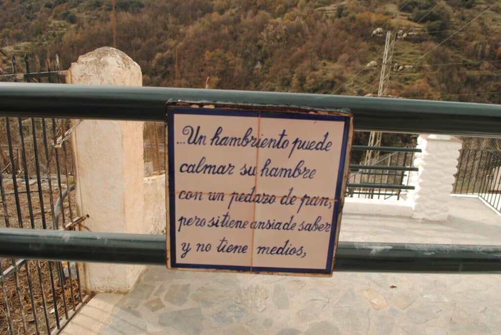 Séptimo verso del Paseo Federico García Lorca en Pampaneira que dice: ... Un hambriento puede calmar su hambre con un pedazo de pan, pero si tiene ansiedad de saber y no tiene medios,