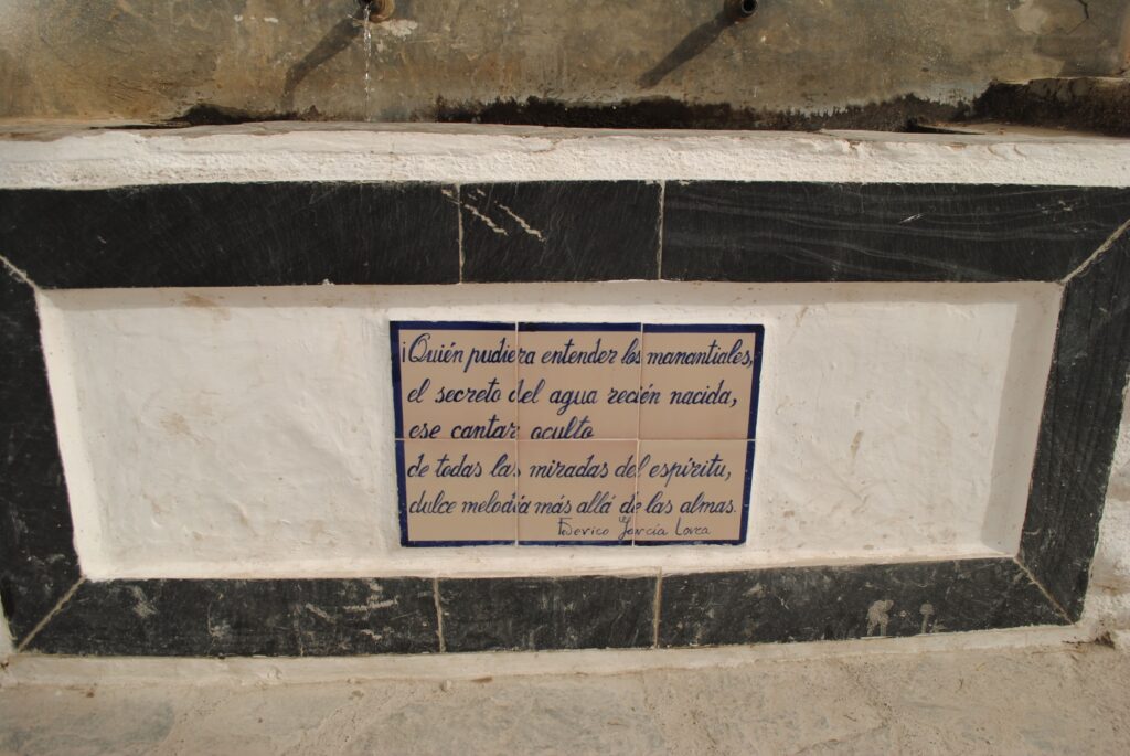 Sexto verso del Paseo Federico García Lorca en Pampaneira que dice: Quién pudiera entender los manantiales, el secreto del agua recién nacida, ese cantar oculto de todas las miradas del espíritu, dulce melodía más allá de las almas.