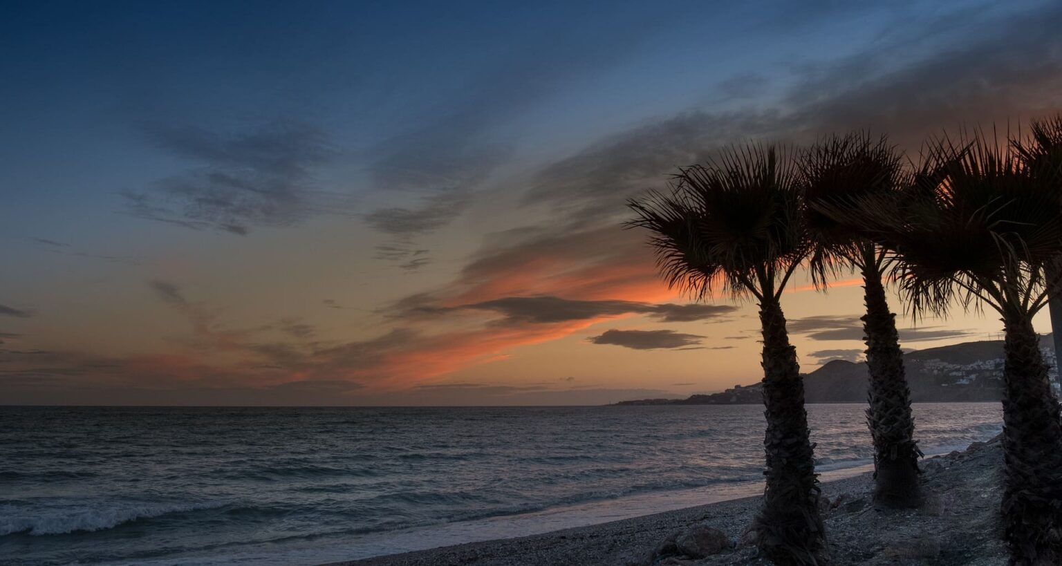 Atardecer desde una de las playas de Nerja con tres palmeras