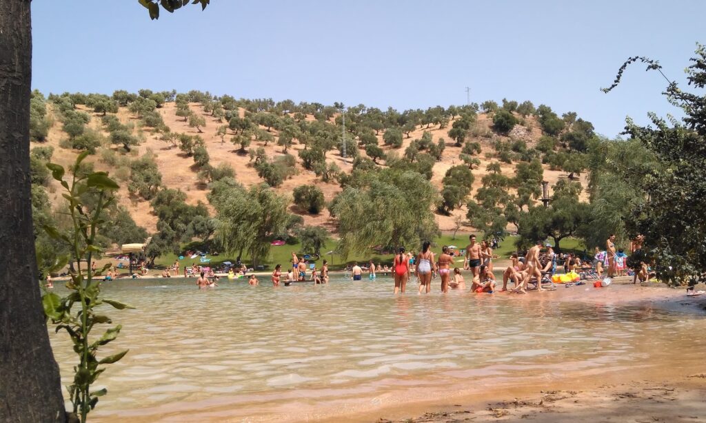 Playa de Arroyomolinos en Zahara de la Sierra con gente bañándose